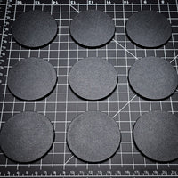 Grouped 60mm round bases on a black background, demonstrating quantity
