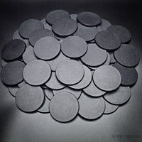 Bulk of 60mm round bases scattered on a black background
