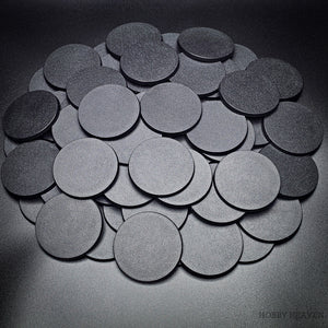 Bulk of 60mm round bases scattered on a black background