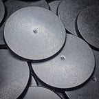 Close-up of 70mm round bases on a black surface
