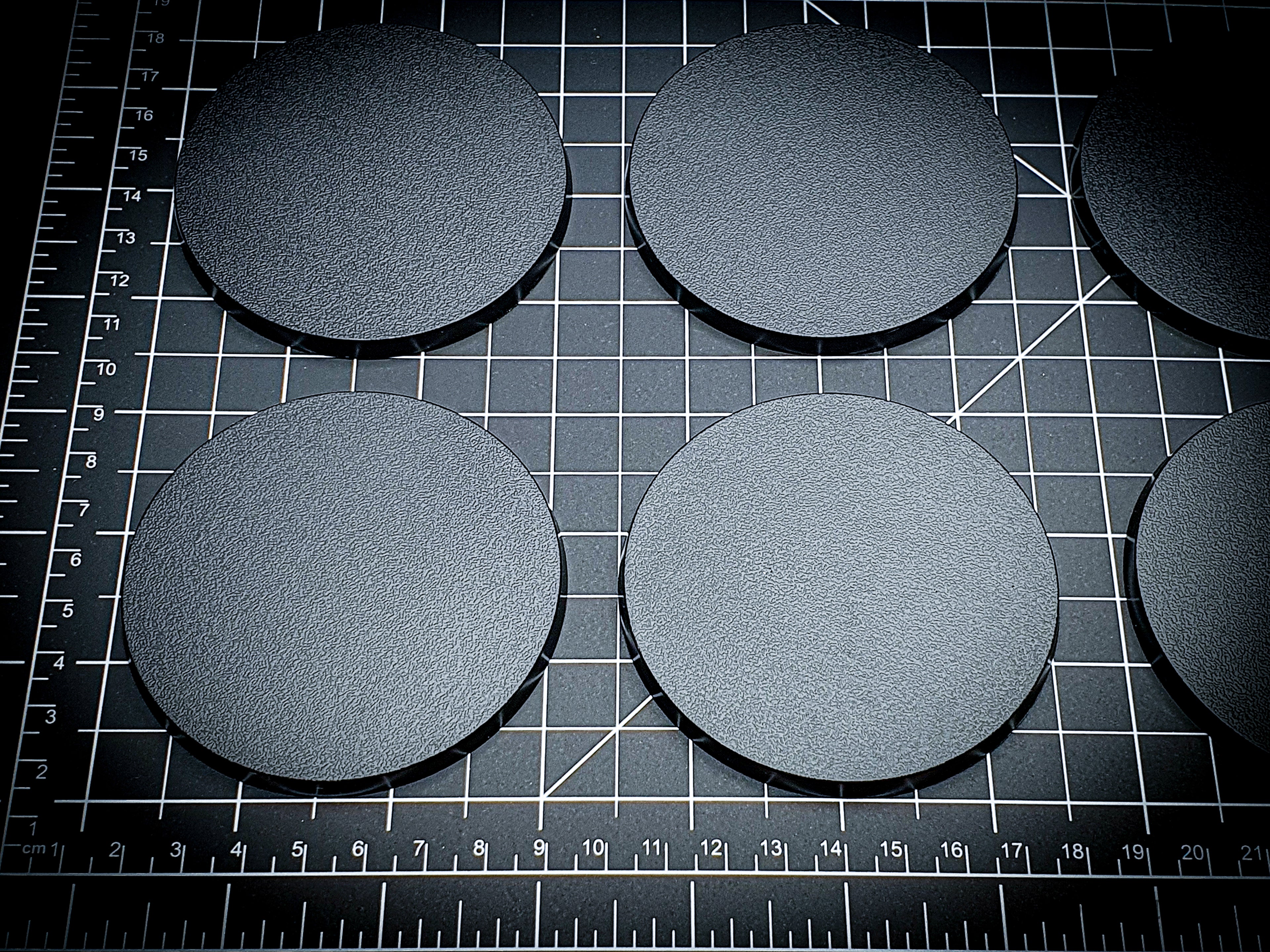 Detailed view of 80mm round bases with texture visible