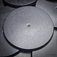 Close-up view of 70mm round bases with a black background, focusing on surface characteristics
