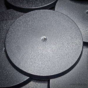 Close-up view of 70mm round bases with a black background, focusing on surface characteristics