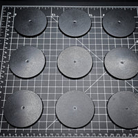 Grouped 70mm round bases on a black background, demonstrating dimensions
