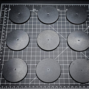 Grouped 70mm round bases on a black background, demonstrating dimensions