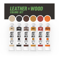 AK Interactive AKABT311 Leather and Wood Set displaying all six oil paint tubes alongside color swatches of each shade, arranged to showcase the range of warm tones perfect for creating realistic leather and wood effects in scale modeling
