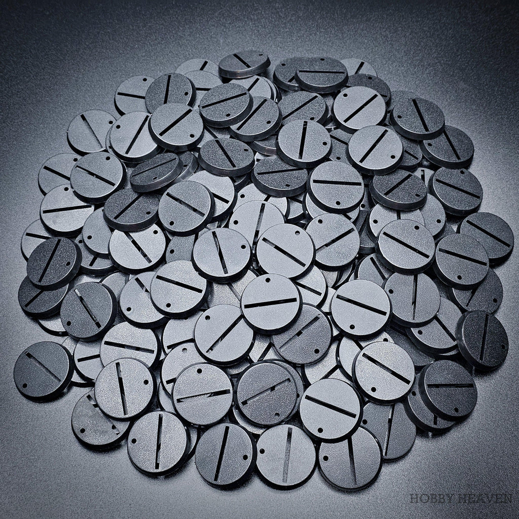 Detailed close-up of 32mm round slotted bases on a pile of various bases.