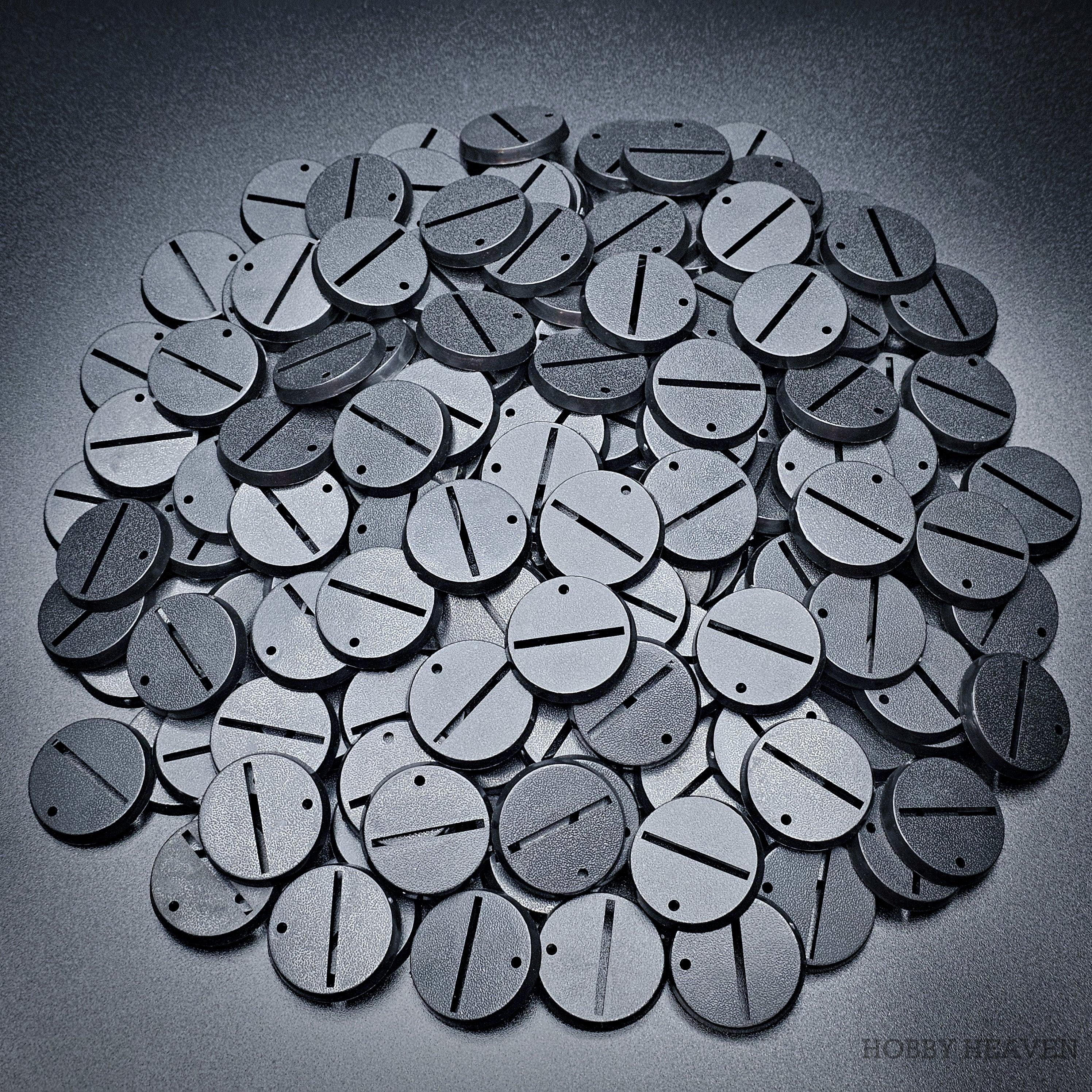 Detailed close-up of 32mm round slotted bases on a pile of various bases.