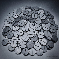 Detailed close-up of 32mm round slotted bases on a pile of various bases.
