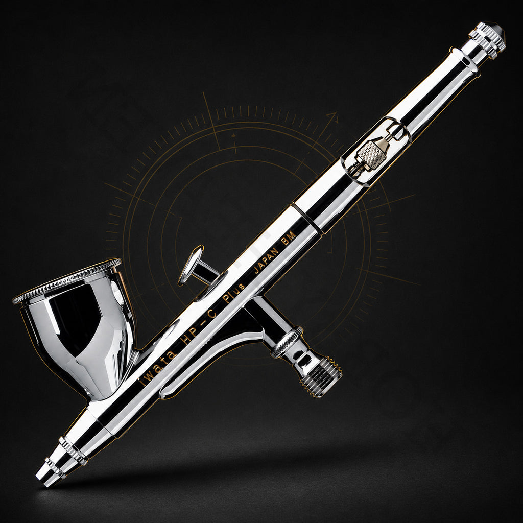 Iwata HP-C Plus at an angle against black, showing the trigger, needle-chucking nut and cutaway handle