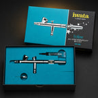 Iwata Eclipse HP-BS in its open teal presentation box with a tube of Iwata Lube in the upper recess
