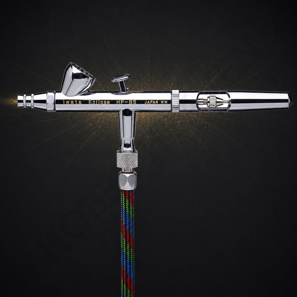 Iwata Eclipse HP-BS seen from the front, connected to a braided multicoloured airbrush hose