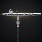 Iwata Eclipse HP-BS seen from the front, connected to a braided multicoloured airbrush hose