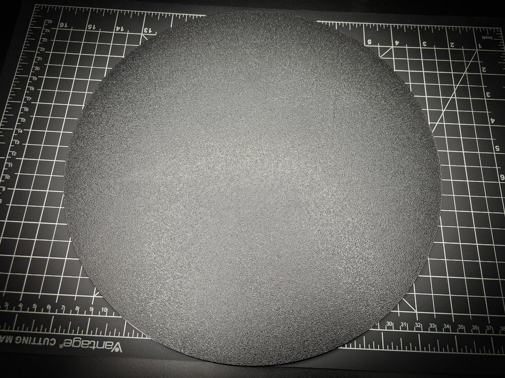 Top-down photograph of the 300mm round textured PETG base on a cutting mat, showing the matte stippled surface filling nearly the entire mat.