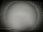Top-down photograph of the 300mm round textured PETG base on a cutting mat, showing the matte stippled surface filling nearly the entire mat.