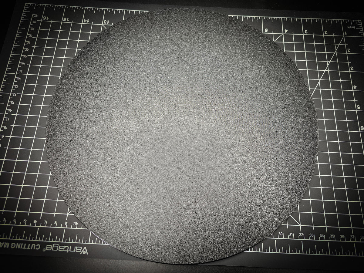 Top-down photograph of the 300mm round textured PETG base on a cutting mat, showing the matte stippled surface filling nearly the entire mat.