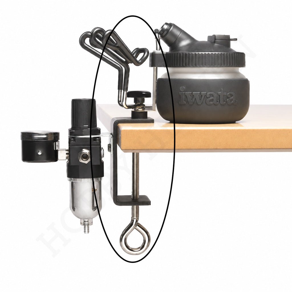 Iwata IWA-AH-400 holder clamped to a workbench with a regulator and Iwata spray-out pot, showing a full workstation setup