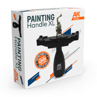 AK Interactive AK9564 Painting Handle XL retail box showing the handle with wide black platform, mounted warrior figure, 40mm and larger badge, and side profile view of the grip mechanism
