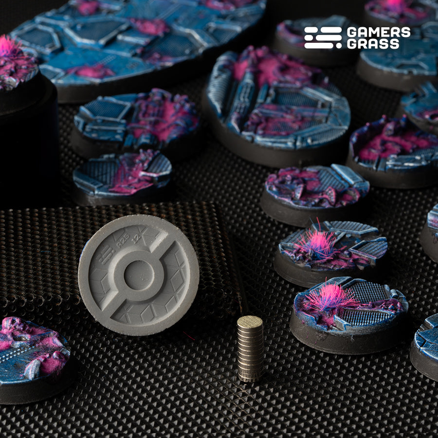 Close-up of 25mm Alien Infestation base bottom showing 6mm magnet slot and installed magnet example on dark background


