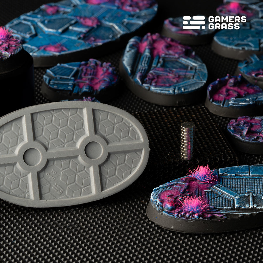 Close-up of 60mm oval Alien Infestation base showing multiple 6mm magnet slots and magnet installation example
