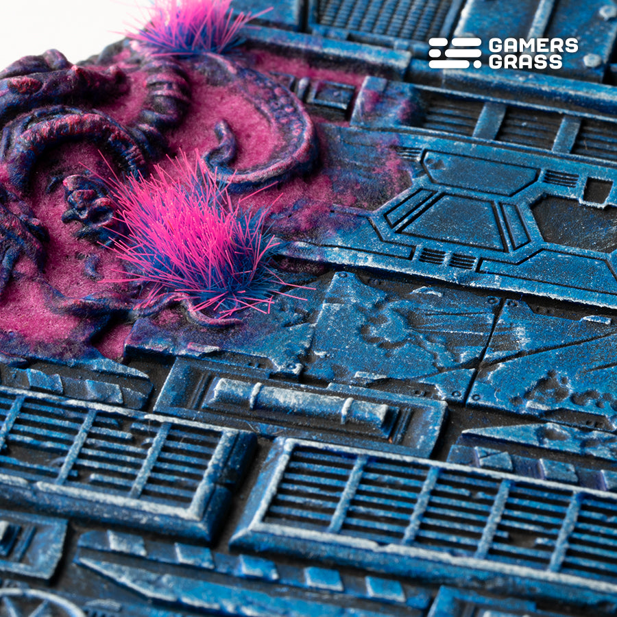 Macro of a 100mm Alien Infestation base: two pink tufts on swollen magenta growth over riveted blue plating