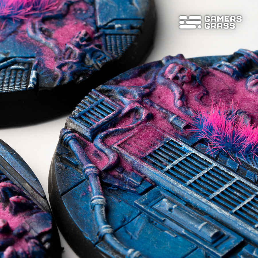 Close-up of a 60mm Alien Infestation base: pipework and grilles under magenta biomass beside a pink and blue tuft