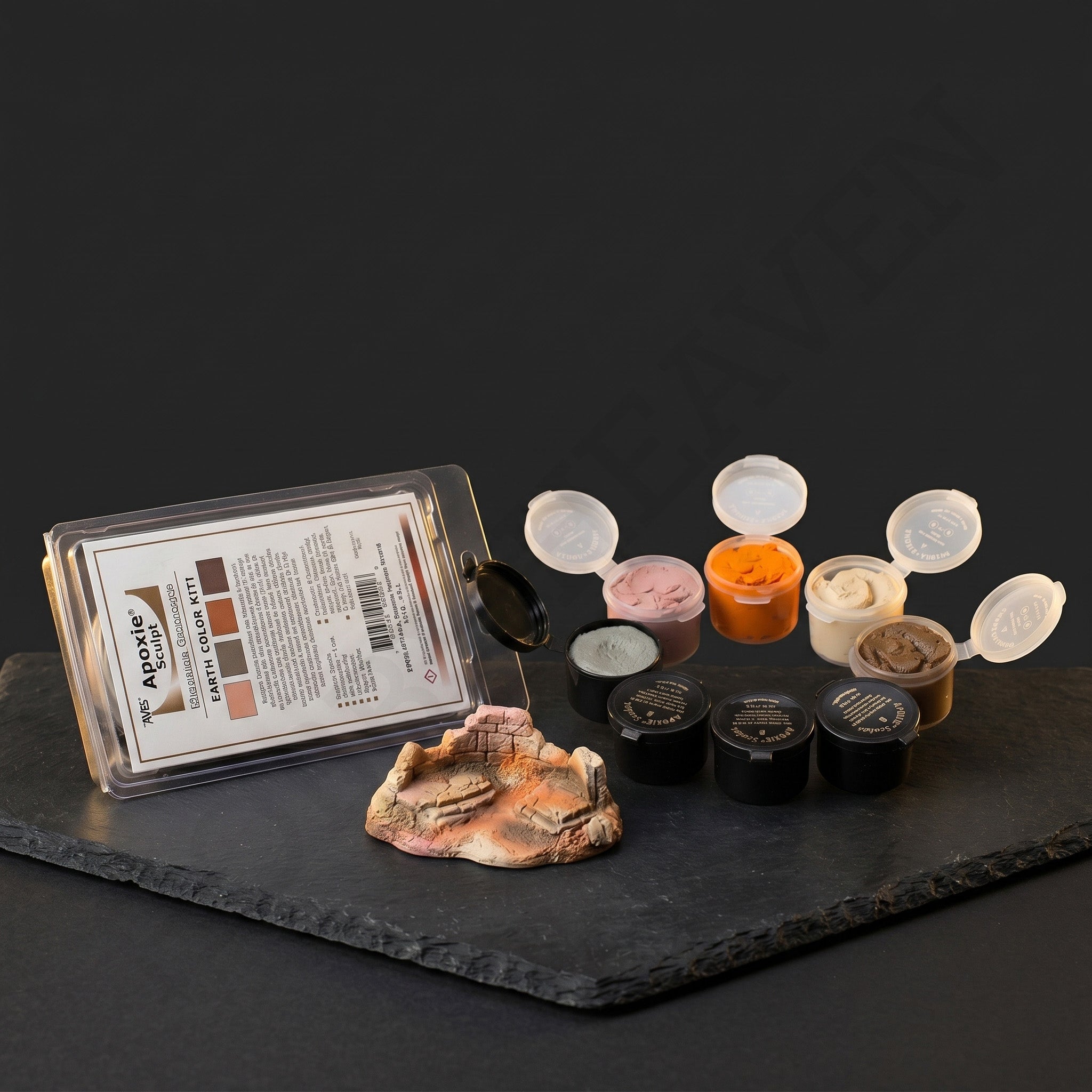 Aves Apoxie Sculpt Earth Colour Kit with open earth-tone sample pods and sculpted terrain sample, showing pink, natural, orange and bronze colours for mixing and modelling