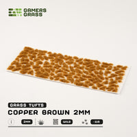 Sheet of 115 Copper Brown 2mm tufts, displaying various shapes and sizes of realistic, light copper-toned grass ready for application
