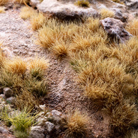 Arid landscape diorama featuring Dry Tuft 6mm - Small Tufts, showcasing realistic dry vegetation in a semi-desert or mountain cliff scene with miniature figures
