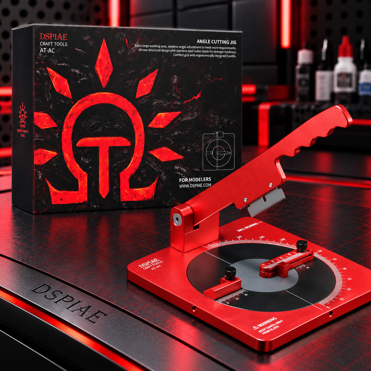 DSPIAE AT-AC angle cutting jig with its wavy red handle raised, in front of the black Angle Cutting Jig box