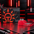 DSPIAE AT-GA super glue applicator stand, red aluminium with two steel columns, beside its box on a red-lit desk