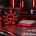 DSPIAE AT-RS photo-etched rolling set: red aluminium block with six steel rods, in front of its box on a red-lit desk