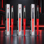 Three DSPIAE Phoenix Plume handles, red with clear caps, standing beside their boxes on a red-lit desk