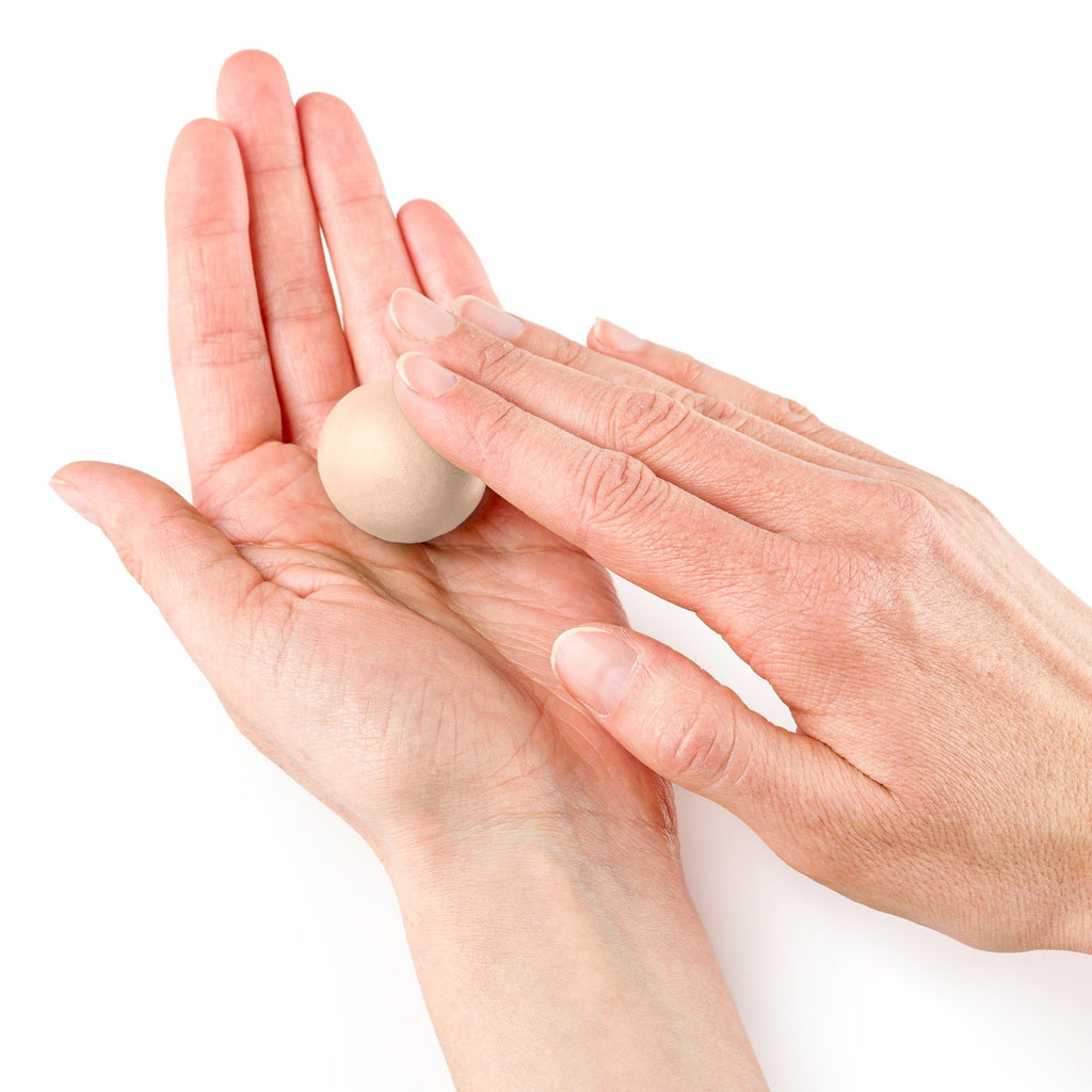 Hands shaping a ball of FIMO Professional Dolphin Grey polymer clay for modelling