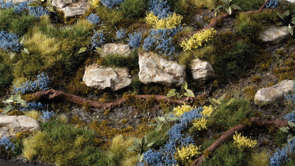 Gamers Grass Bluebeard Flowers Tufts applied on diorama terrain with rocks, shrubs and scenic basing for miniatures