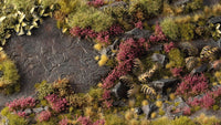 Miniature diorama decorated with Gamers Grass Heather Flowers tufts, showing purple heather on rocky moorlands with grass and plants.
