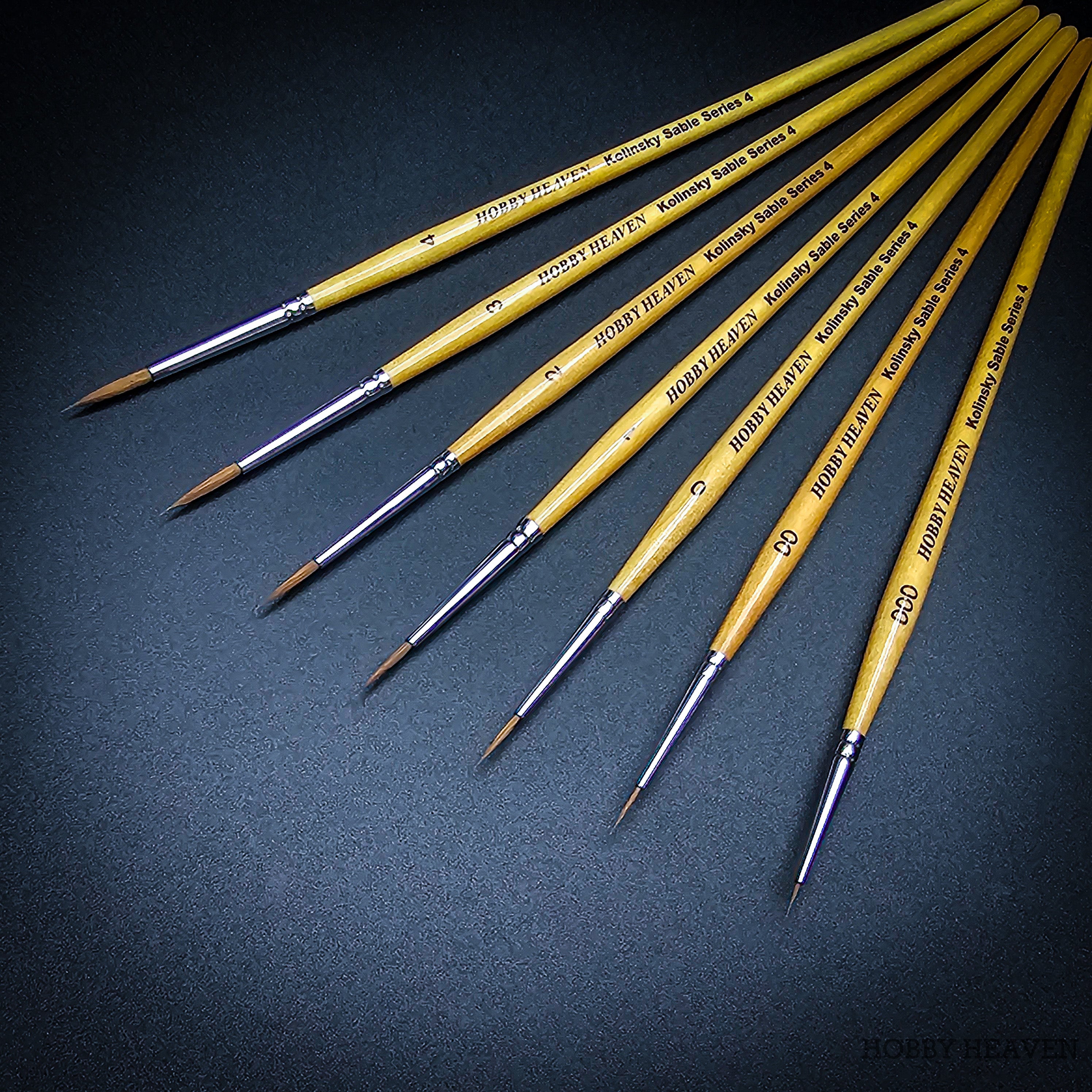 Series 4 Kolinsky Sable complete size range — sizes 000 to 4 with natural birch handles on dark background