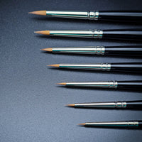 Winsor & Newton Kolinsky Sable Brush set - 7 diverse sizes contrasting on black surface
