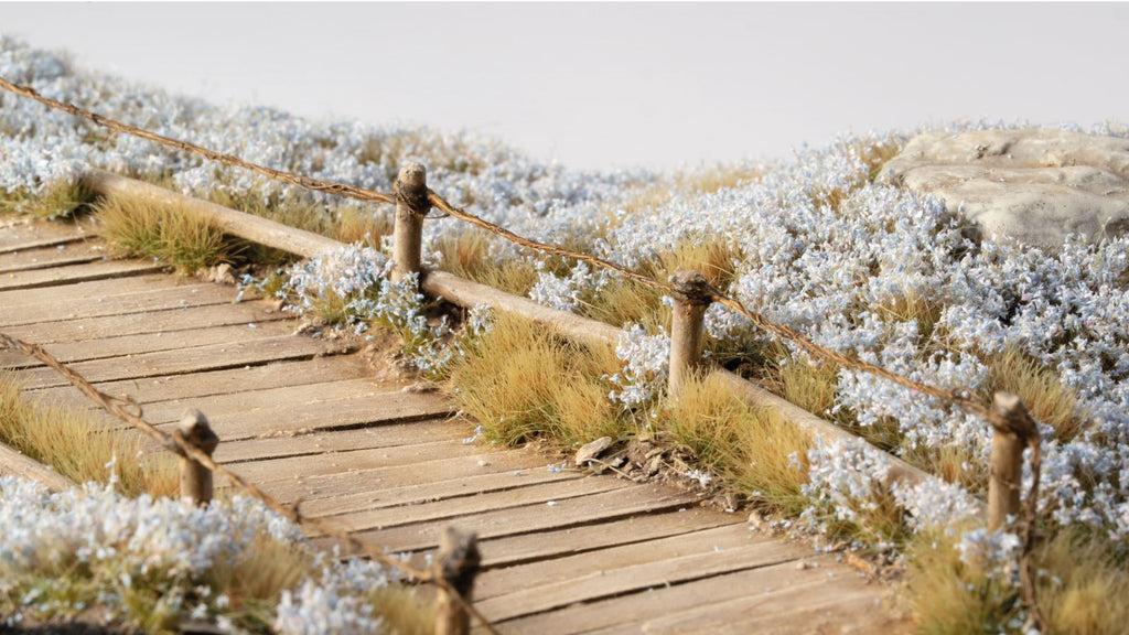 Miniature terrain decorated with GamersGrass Light Blue Lilac Flowers tufts – perfect for scale models, wargaming bases and scenic dioramas