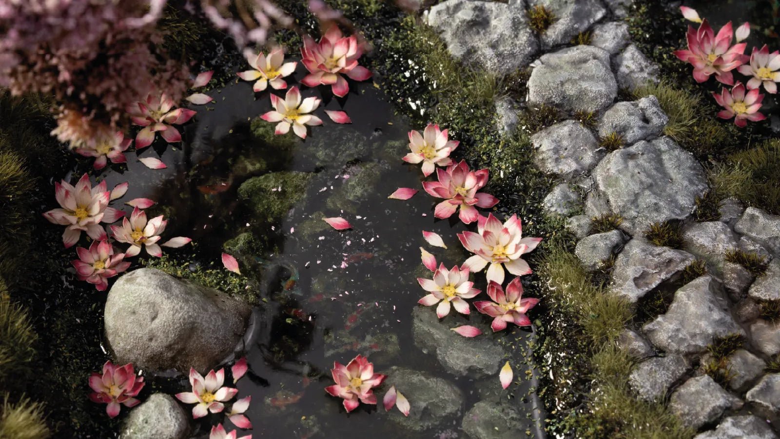Gamers Grass Lotus Flower blooms placed on scenic pond diorama with resin water effect rocks and moss