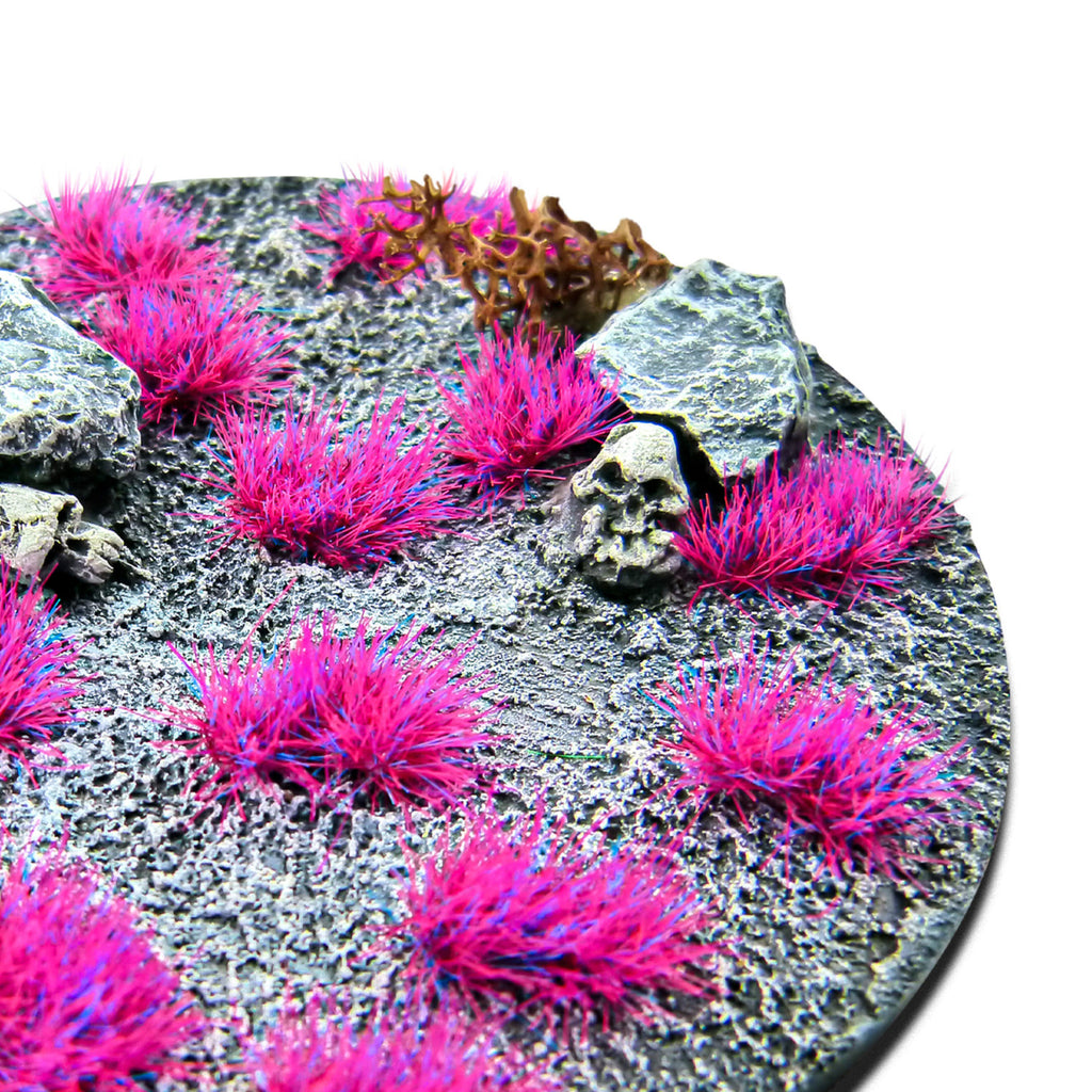 Andromeda Pink Martian Fluor Tufts planted on a grey textured base with a skull and rocks