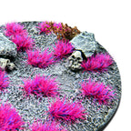 Andromeda Pink Martian Fluor Tufts planted on a grey textured base with a skull and rocks