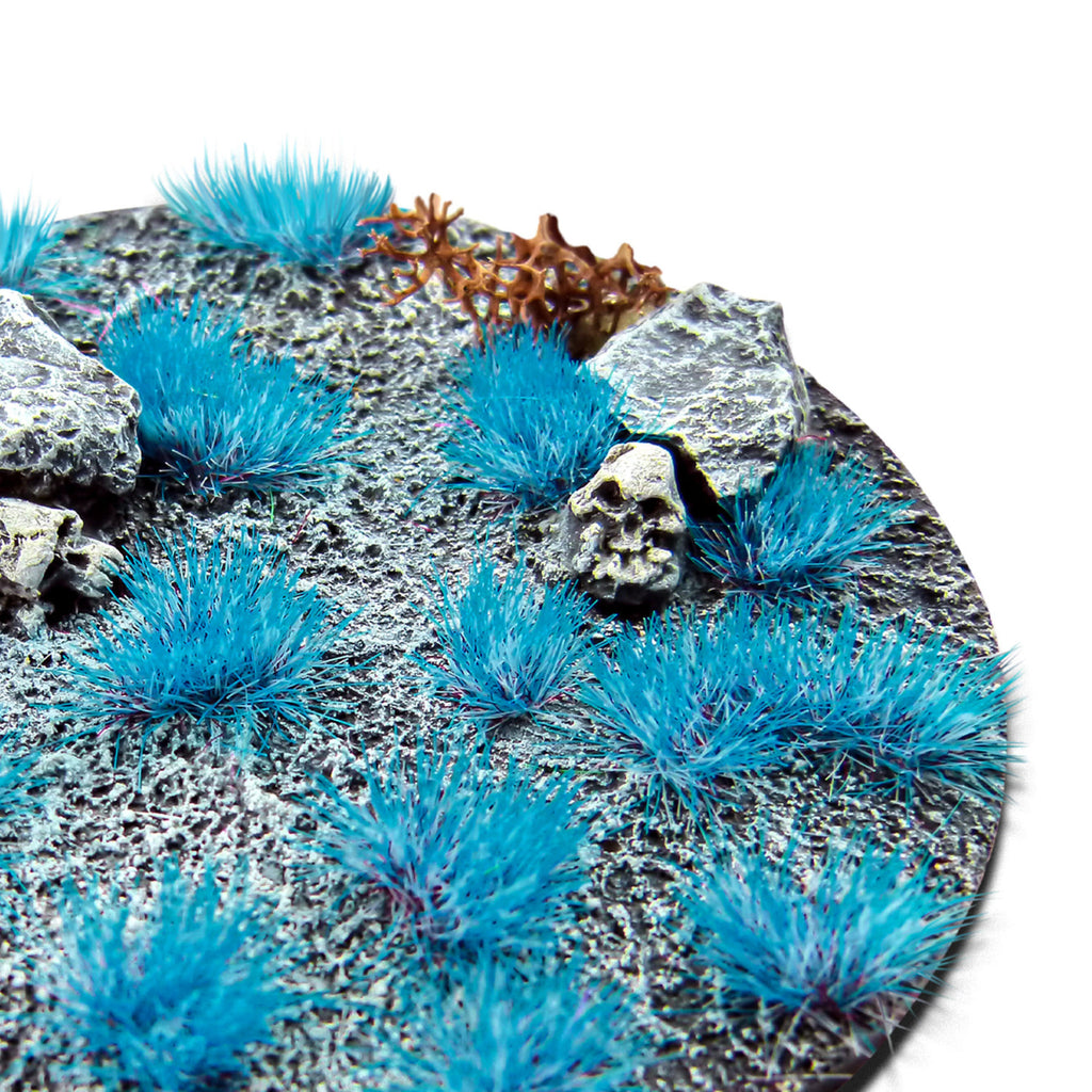 Neon Stitch Blue Martian Fluor Tufts planted on a grey textured base with a skull and rocks
