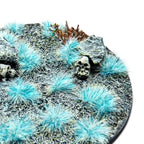 Neon Yeti Blue Martian Fluor Tufts planted on a grey textured base with a skull and rocks