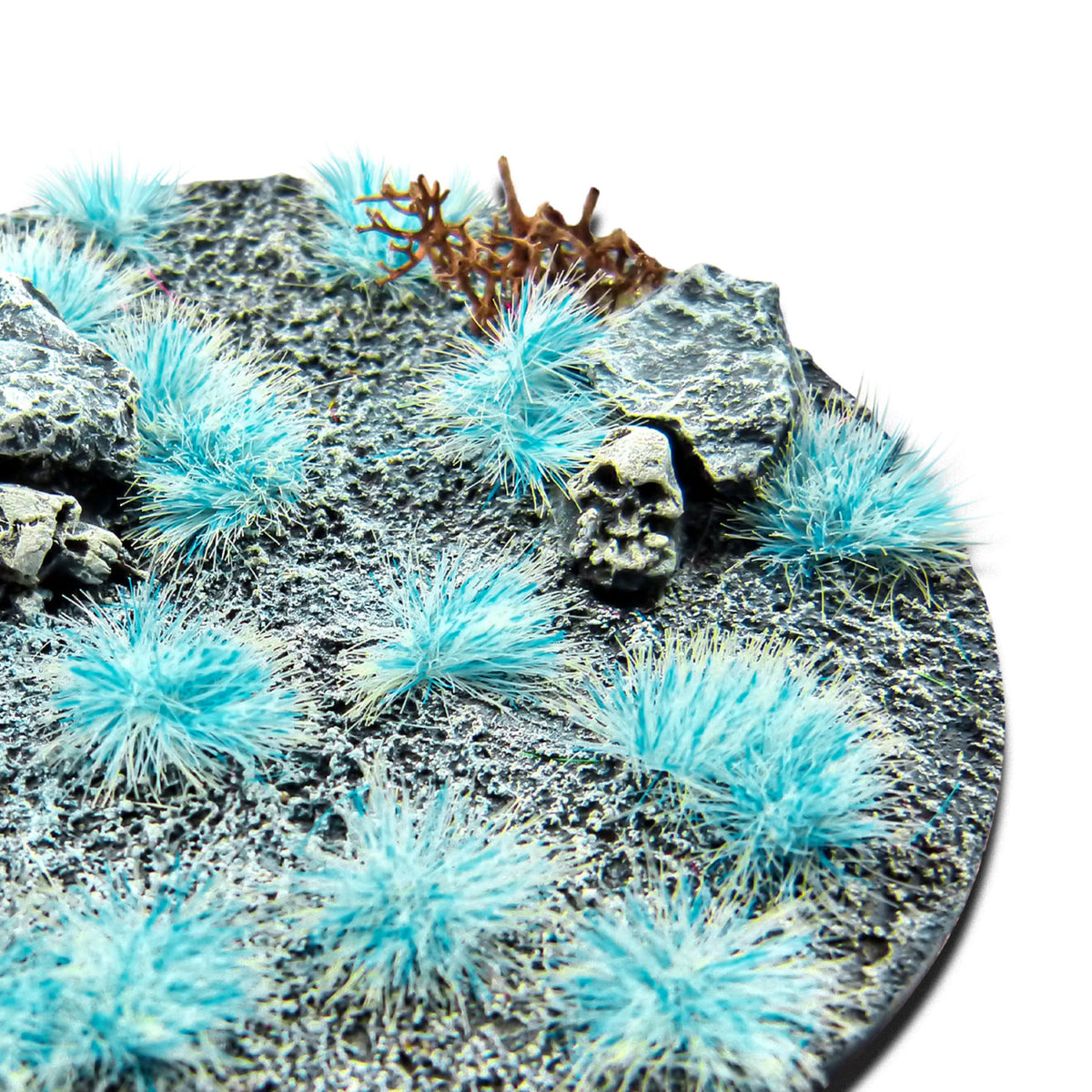 Neon Yeti Blue Martian Fluor Tufts planted on a grey textured base with a skull and rocks