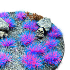 Sulley Purple-Blue Martian Fluor Tufts planted on a grey textured base with a skull and rocks