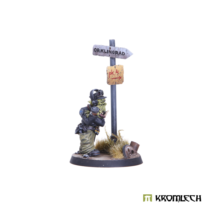 The Orc Tank Commander turned to the side, arms drawn in, beside the signpost; scenic base not included