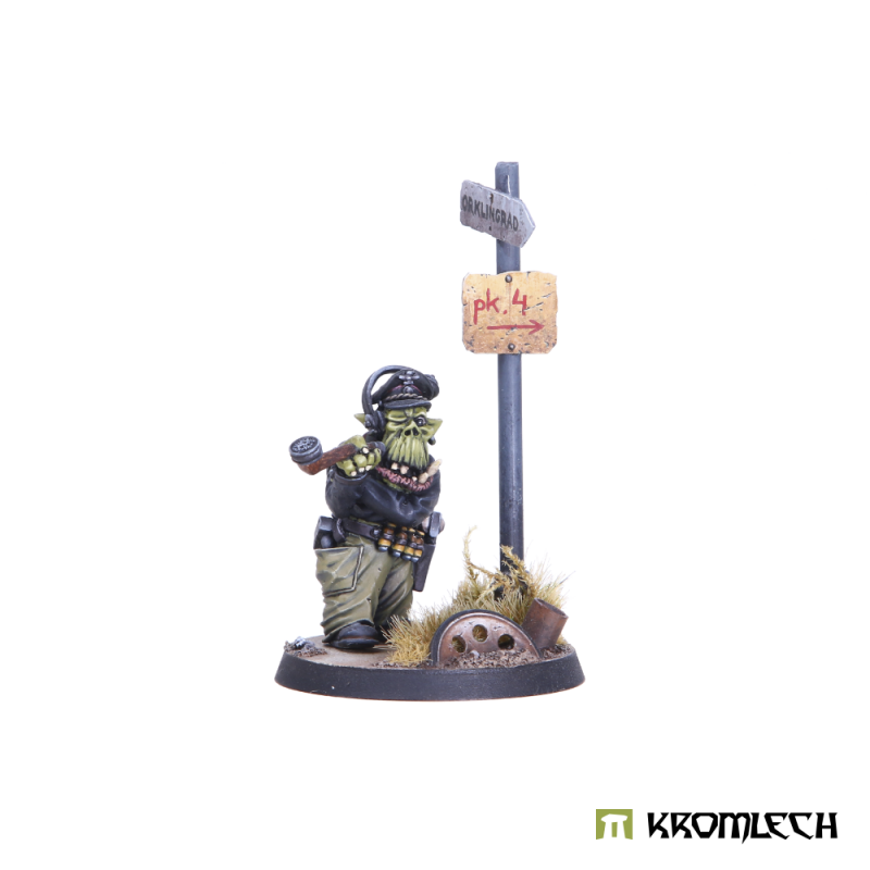 Kromlech Orc Tank Commander painted: orc in a peaked cap and headset holding a pipe, by a signpost on a scenic base