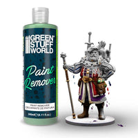 Green Stuff World paint remover bottle next to a fantasy figurine on a white background