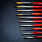 Close-up of Raphael Series 8394 Kaerell round brushes with red handles for fine detail and watercolour painting